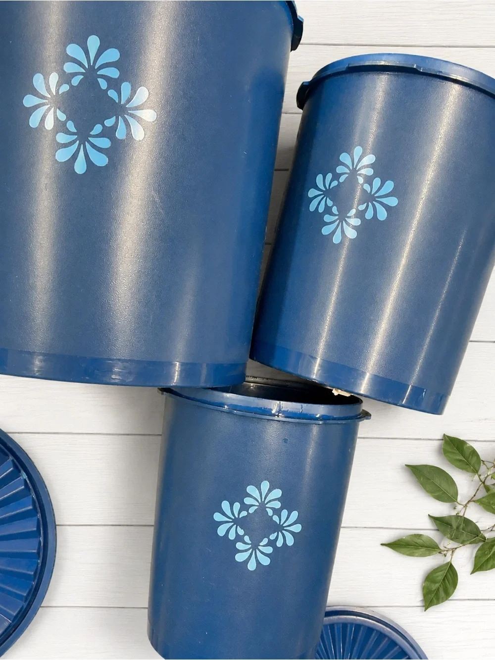 vintage dark blue Tupperware Servalier nesting canisters with a floral starburst